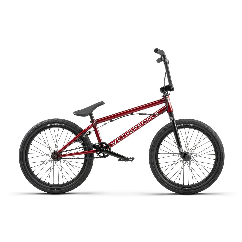 The Wethepeople Versus 20 Inch Bike in red features black handlebars, seat, and tires. Shown in profile view, its chromoly frame displays the "WeThePeople" brand name.