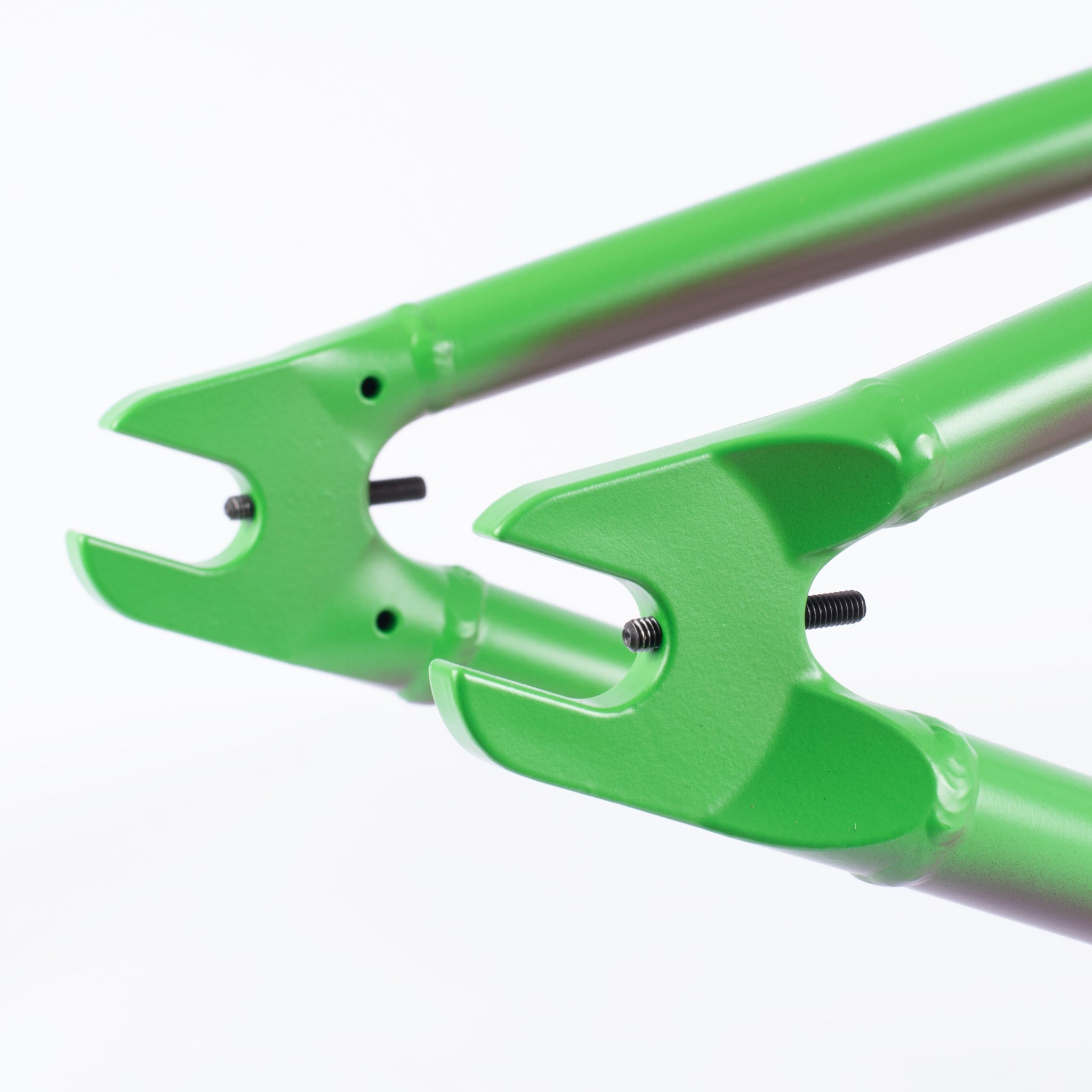 Close-up of two green investment cast dropouts with bolts on a Cult Biggie Frame (Alex Kennedy Signature), set against a white background.