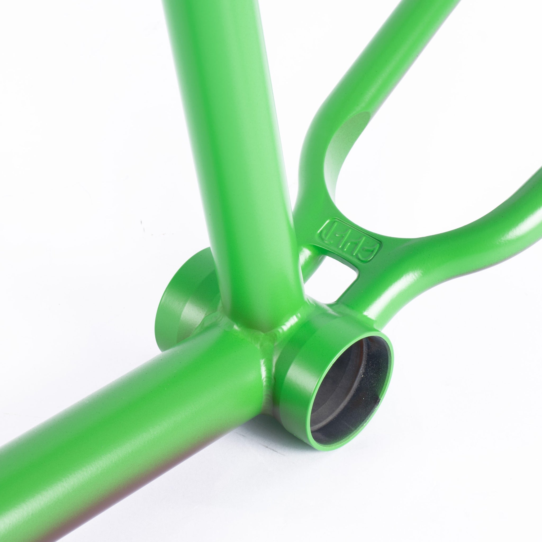 Close-up view of the green Cult Biggie Frame (Alex Kennedy Signature), highlighting the bottom bracket area and chainstay junction with investment cast dropouts, set against a white background.