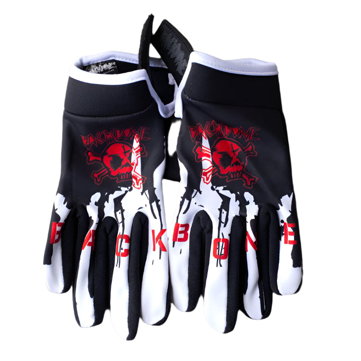 The Backbone Gnar Drip Adult Gloves, made of lightweight spandex, feature a black and white design with a red skull and the words "BACKBONE GNAR DRIP," displayed on a concrete surface.