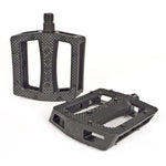 The Shadow Ravager Plastic Pedals are durable black pedals with textured, grippy surfaces and wide openings, shown on a white background.