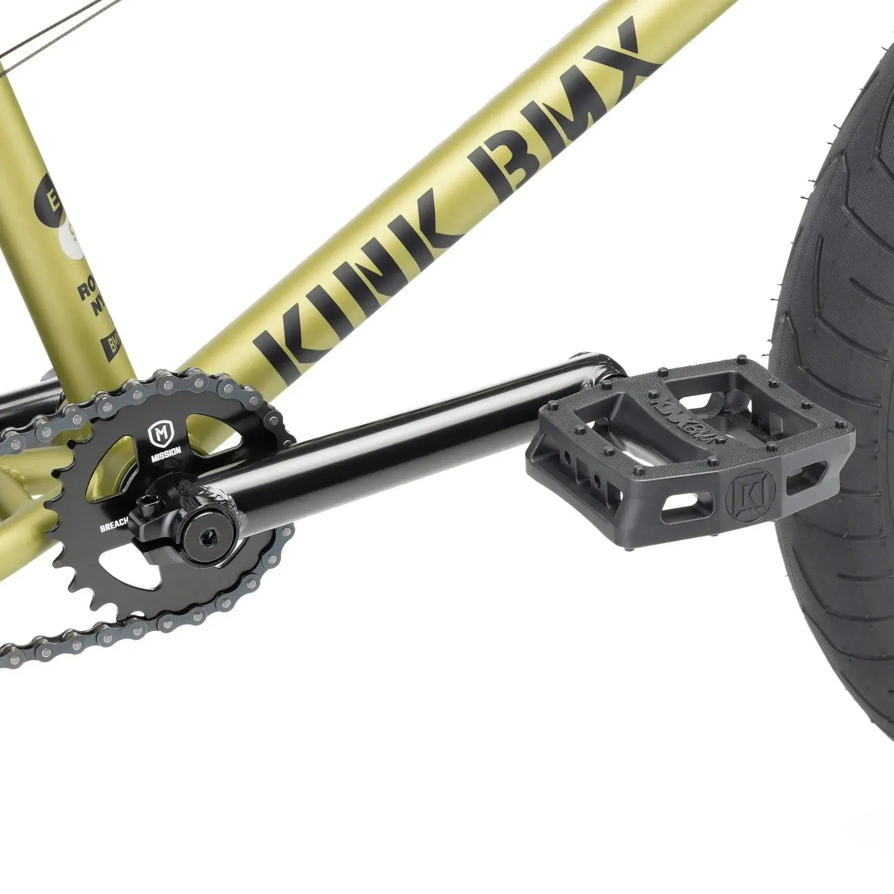 Close-up of the Kink Gap XL 20 Inch Bike (2026) crankset, chainring, and pedal, showing part of the gold 4130 chromoly frame and rear tire.