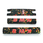 The BMX Crash Pad Set includes three black pads in varying sizes, each featuring bold red "BMX" text and a yellow-green splatter design—perfect for adding stylish protection to your ride.