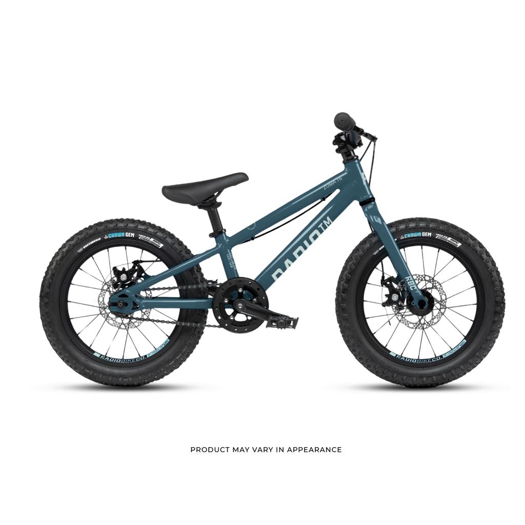 Side view of a blue Radio 16 Inch Zuma Bike, featuring thick tires, disc brakes, and a straight handlebar on a white background. Text below notes that the product may vary in appearance.