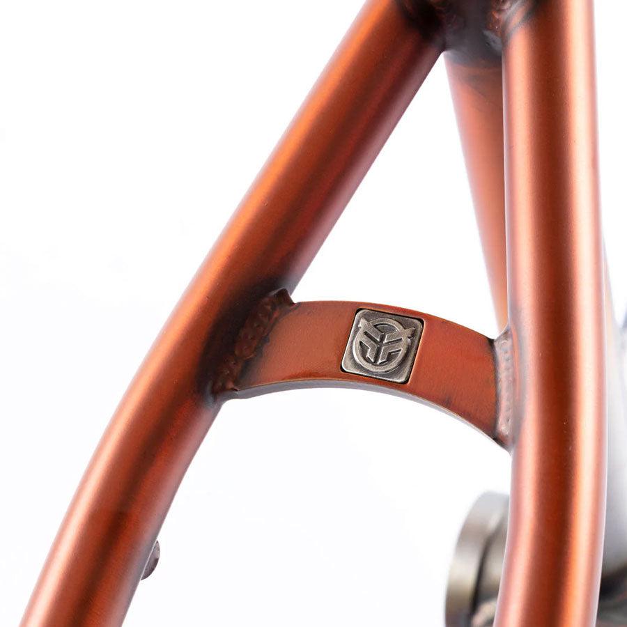 A close up of the Federal Bruno Frame, showcasing its Matt Trans Burnt Orange color and Raw Fade aesthetic.