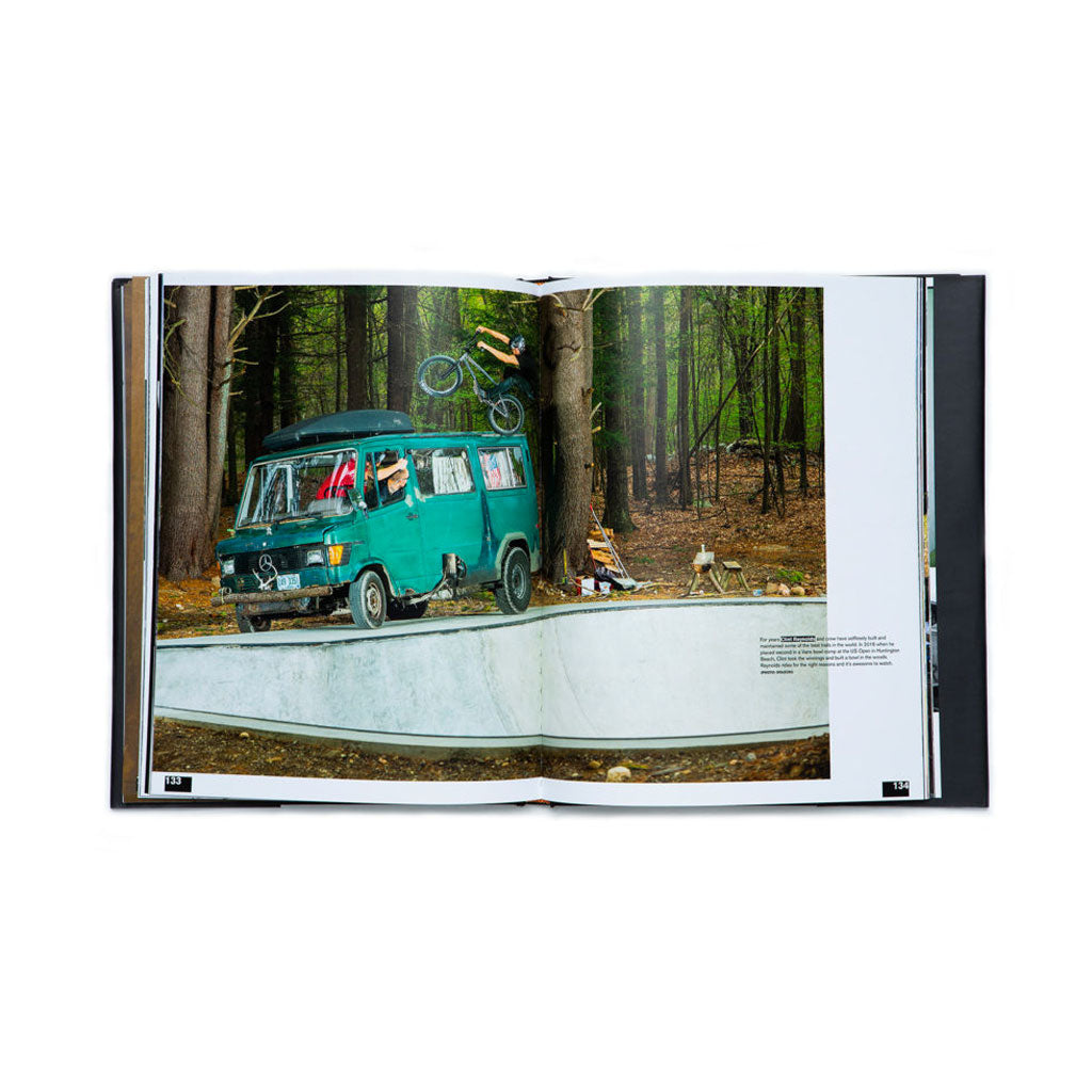 A S&M Behind The Shield Book featuring a picture of a van in the woods and American Bicycle Company.