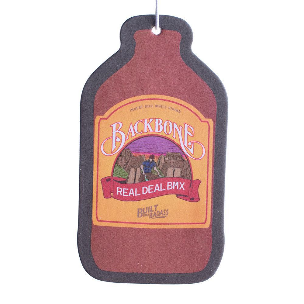 The Backbone Air Freshener, shaped like a bottle and labeled "Backbone Real Deal BMX" and "Built For Badass," releases a spicy pineapple aroma, perfect for those who embrace an adventurous lifestyle.