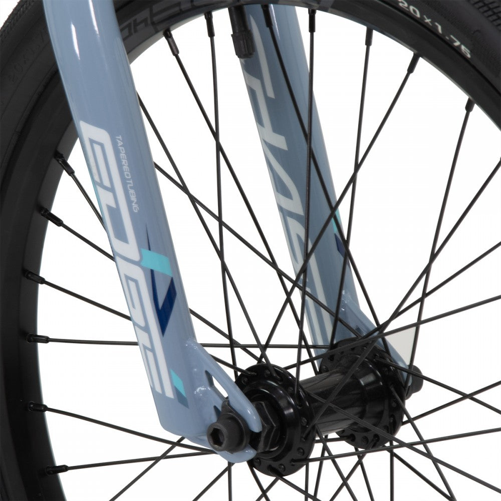 A close up of a blue Chase Edge Pro Cruiser Bike (2024) with black spokes.