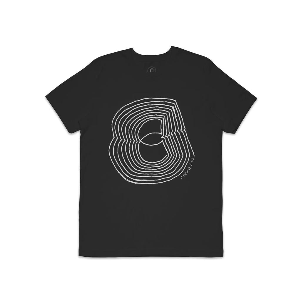 The Cinema Maze T-Shirt is a black tee featuring a white abstract layered design of concentric circular lines. It offers a modern silhouette with an ultra-soft feel and has "Como & BnTx" text near the bottom edge.