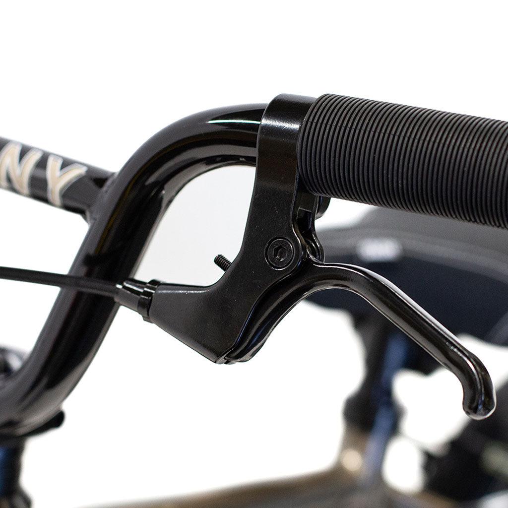 Close-up of a black bicycle brake lever and handlebar grip on a white background, showcasing the sleek design that complements the lightweight alloy frame of the Colony Horizon 12 Inch Bike.