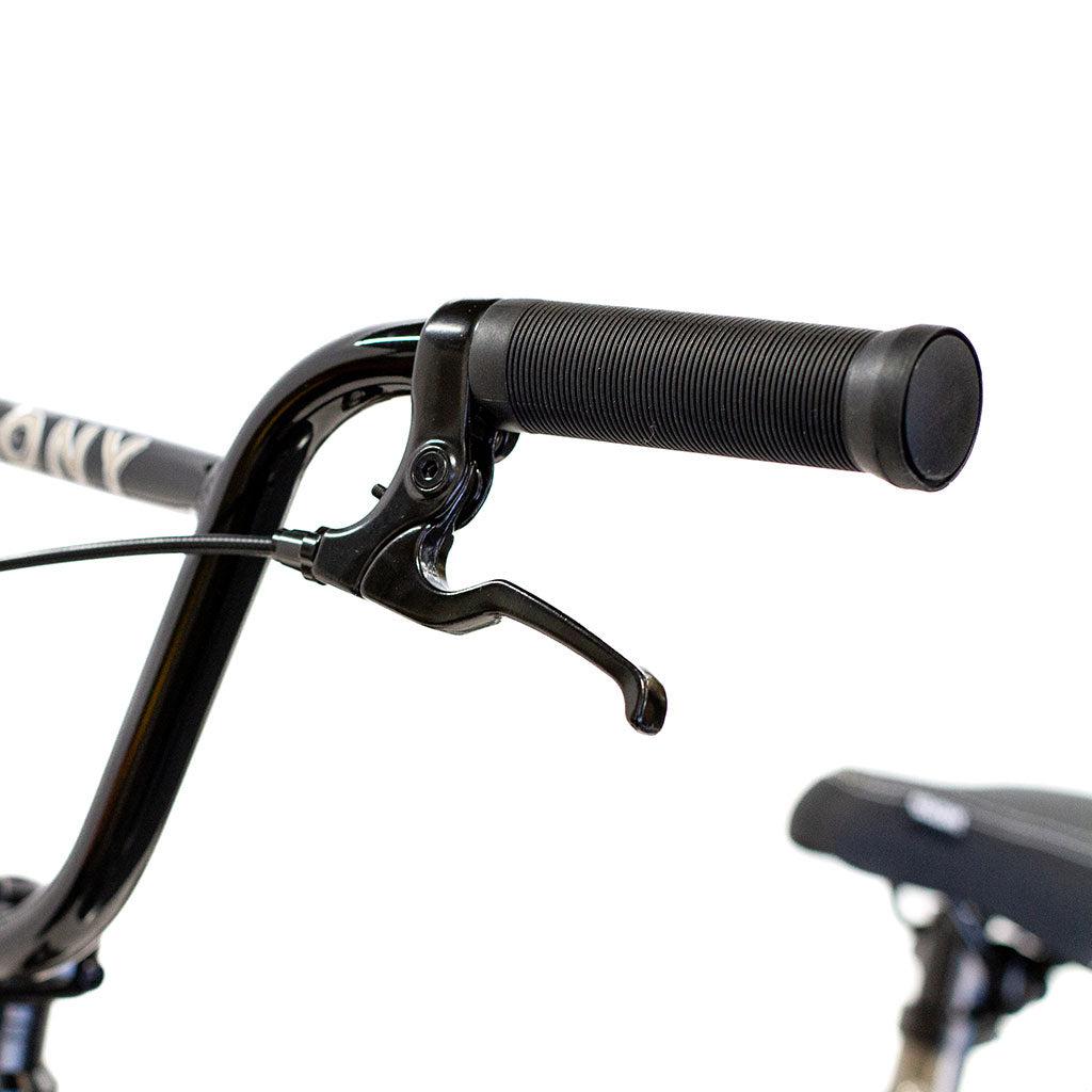 Close-up of a black handlebar with grip and brake lever, plus part of the seat, showcases the BMX-ready Colony Horizon 20 Inch Bike—featuring detailed design elements and a lightweight alloy frame.