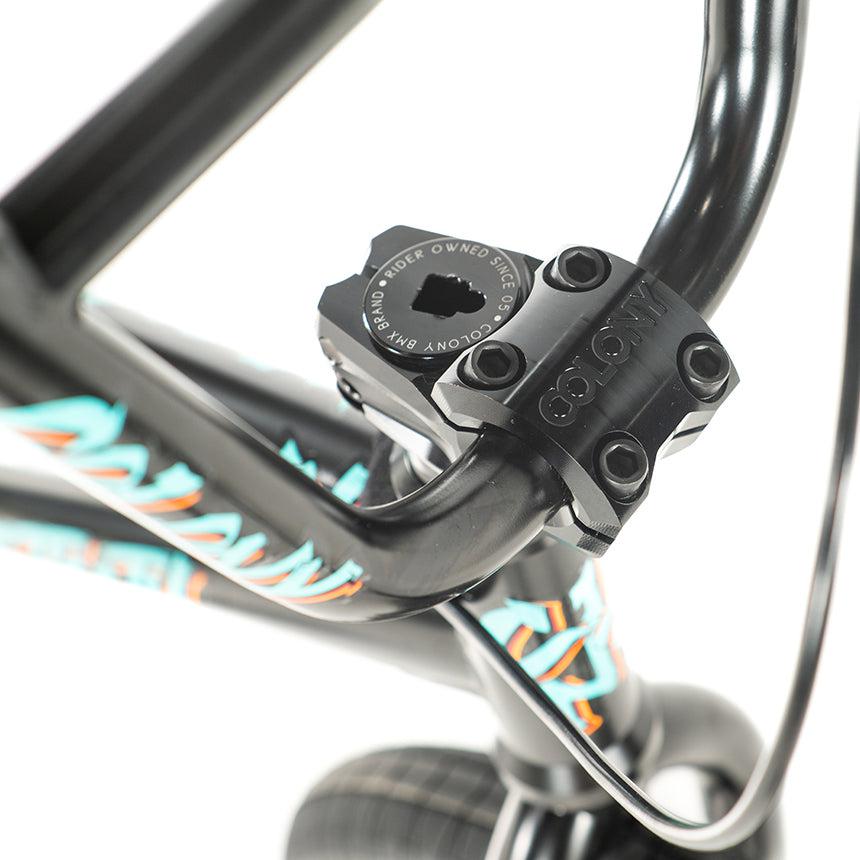 Close-up of the handlebars and stem of the 16-inch Colony Sweet Tooth Pro Elite BMX, featuring black hardware and colorful decals, showcasing its vibrant style.
