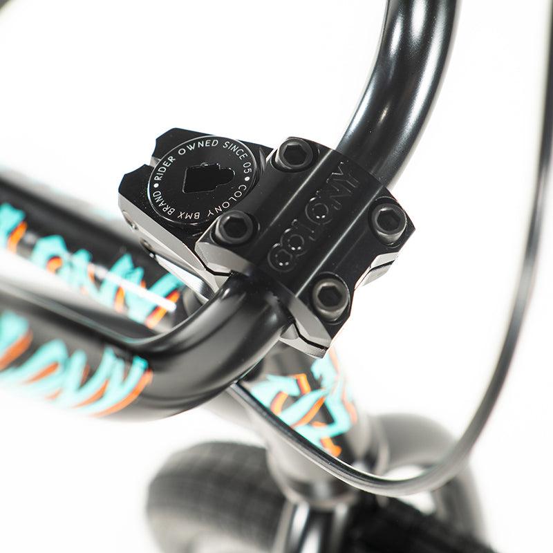 Close-up of the black handlebar stem on a Colony Sweet Tooth Pro Elite 18 Inch BMX Bike, highlighted by colorful accents and an engraved logo.