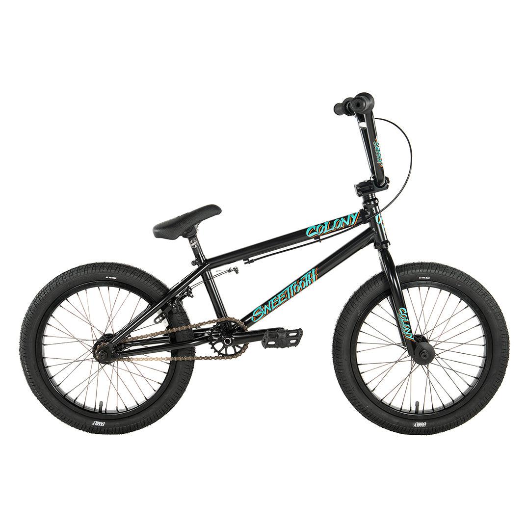 The Colony Sweet Tooth Pro Elite 18 Inch BMX Bike features a black frame with teal accents, compact dimensions, thick tires, and a padded seat, highlighted against a pristine white background.