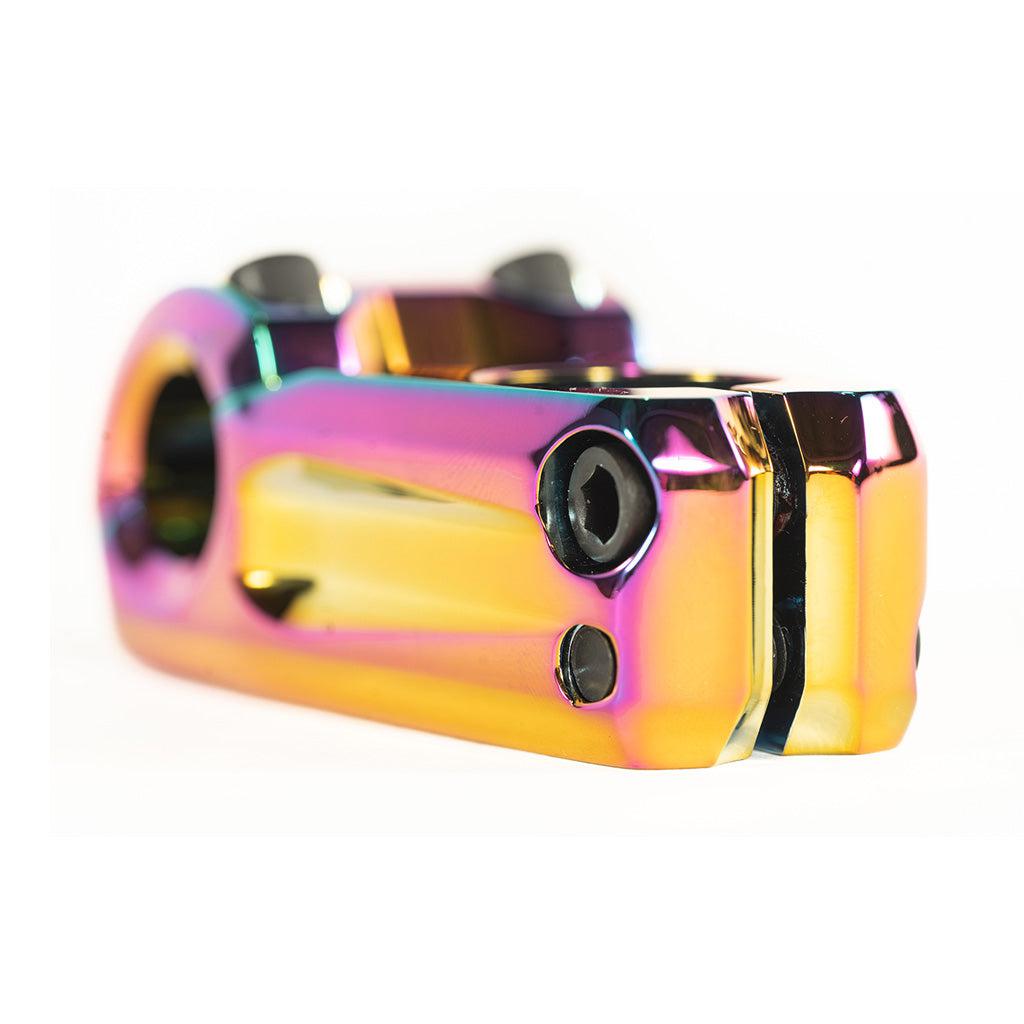 A close up of a Colony Variant 52mm BMX Stem, a rainbow colored bicycle crankset and low-rise alternative for top load stems.