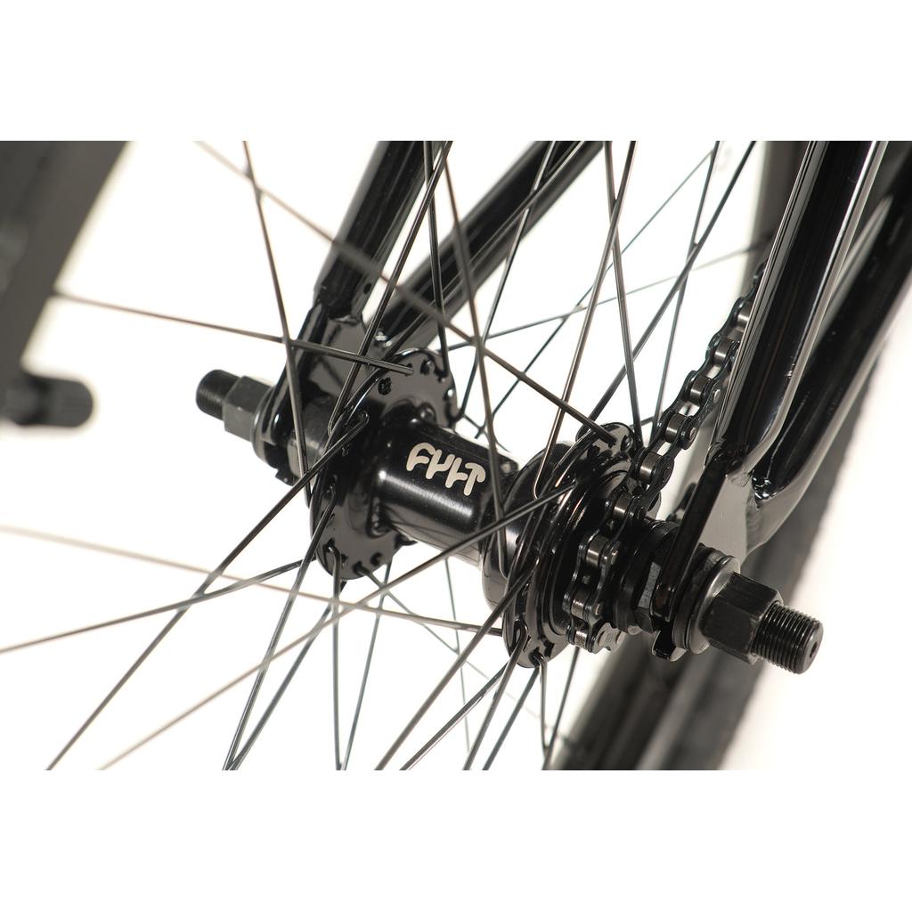 Close-up of a "FYH"-labeled black wheel hub and spokes on the Cult Access 20 Inch Bike, featuring a hi-tensile frame for beginners' manoeuvrability.