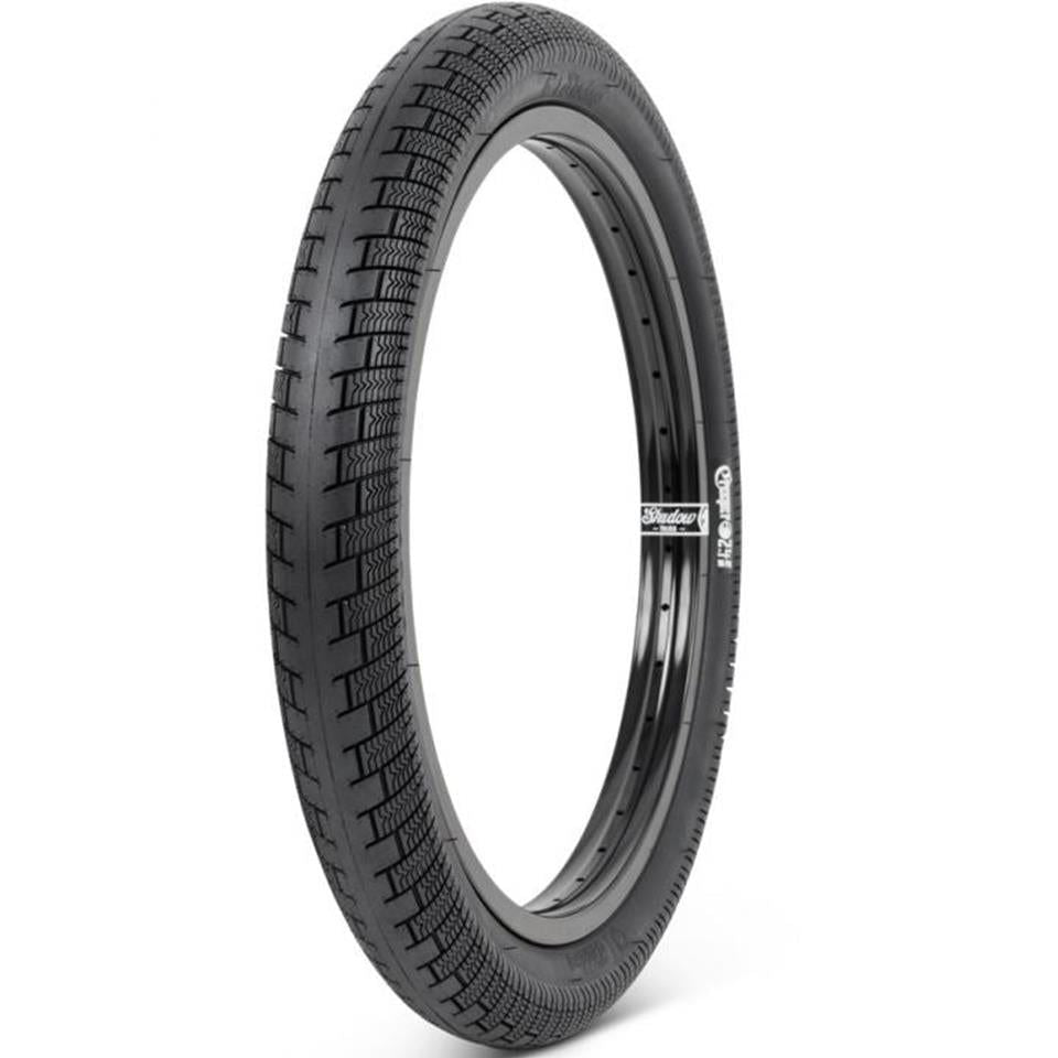 The Shadow Creeper 20 Inch Tyre, featuring a black textured tread, stands upright against a white background.