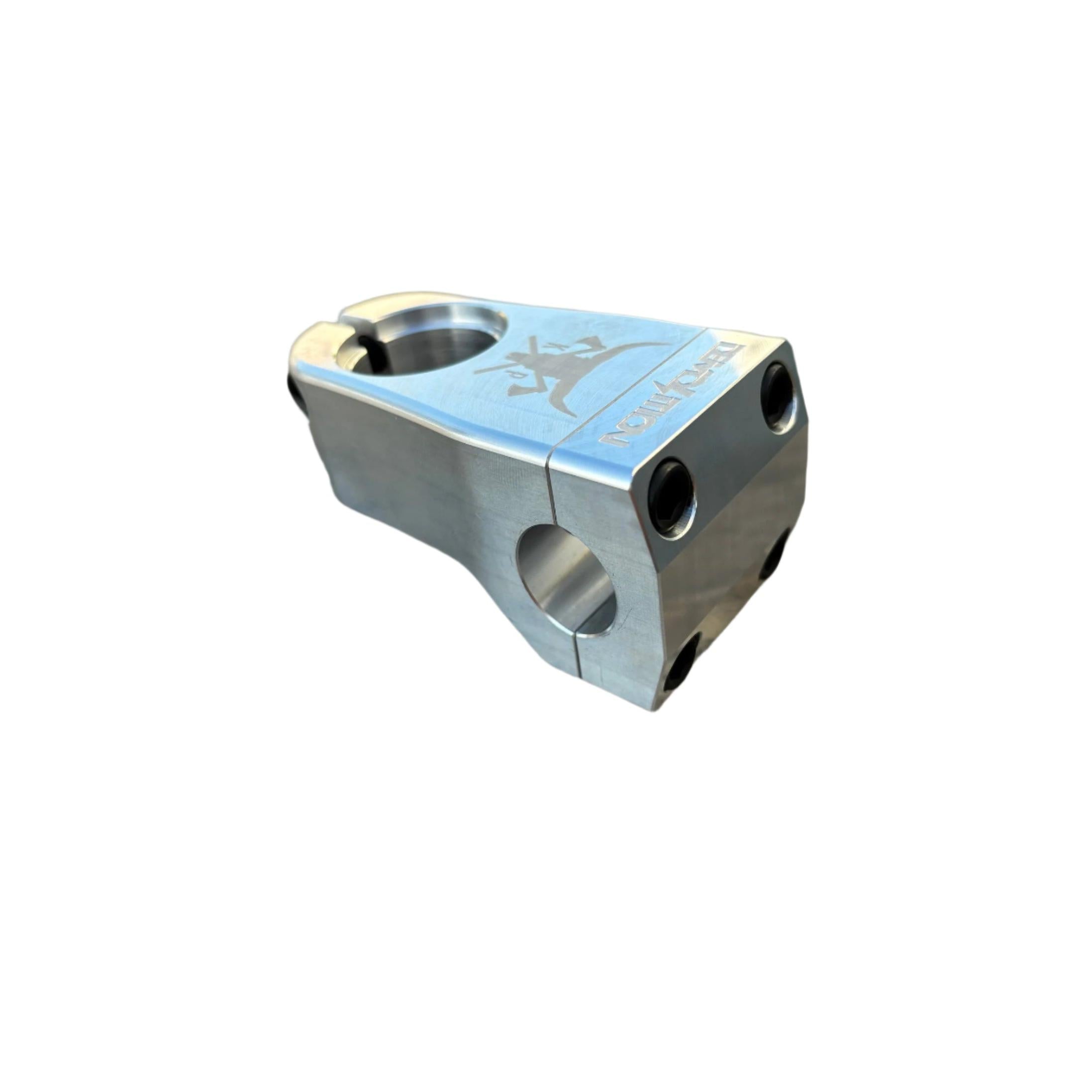 Close-up of a silver Demolition Kevin Peraza Front Load BMX stem featuring a four-bolt faceplate, elegantly marrying style and function as it sits atop a textured, weathered wooden surface.