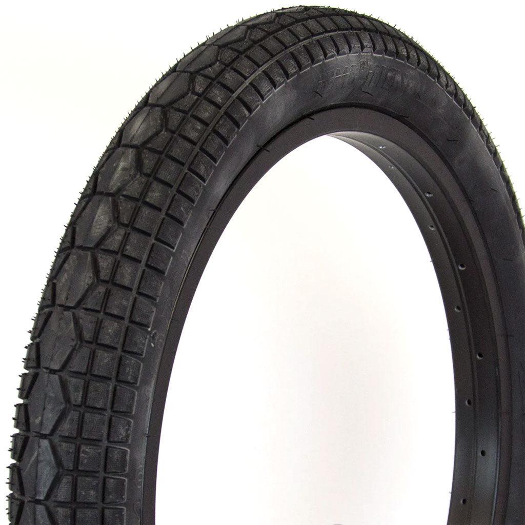 A close-up image of a black Demolition Rig (Dennis Enarson Signature) Tyre with a diamond-shaped tread pattern, positioned against a white background.