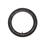 A DRS Vise Camo Tyre with a black exterior and a unique camouflage pattern on the inner surface, optimized for improved traction, is displayed against a simple white backdrop.