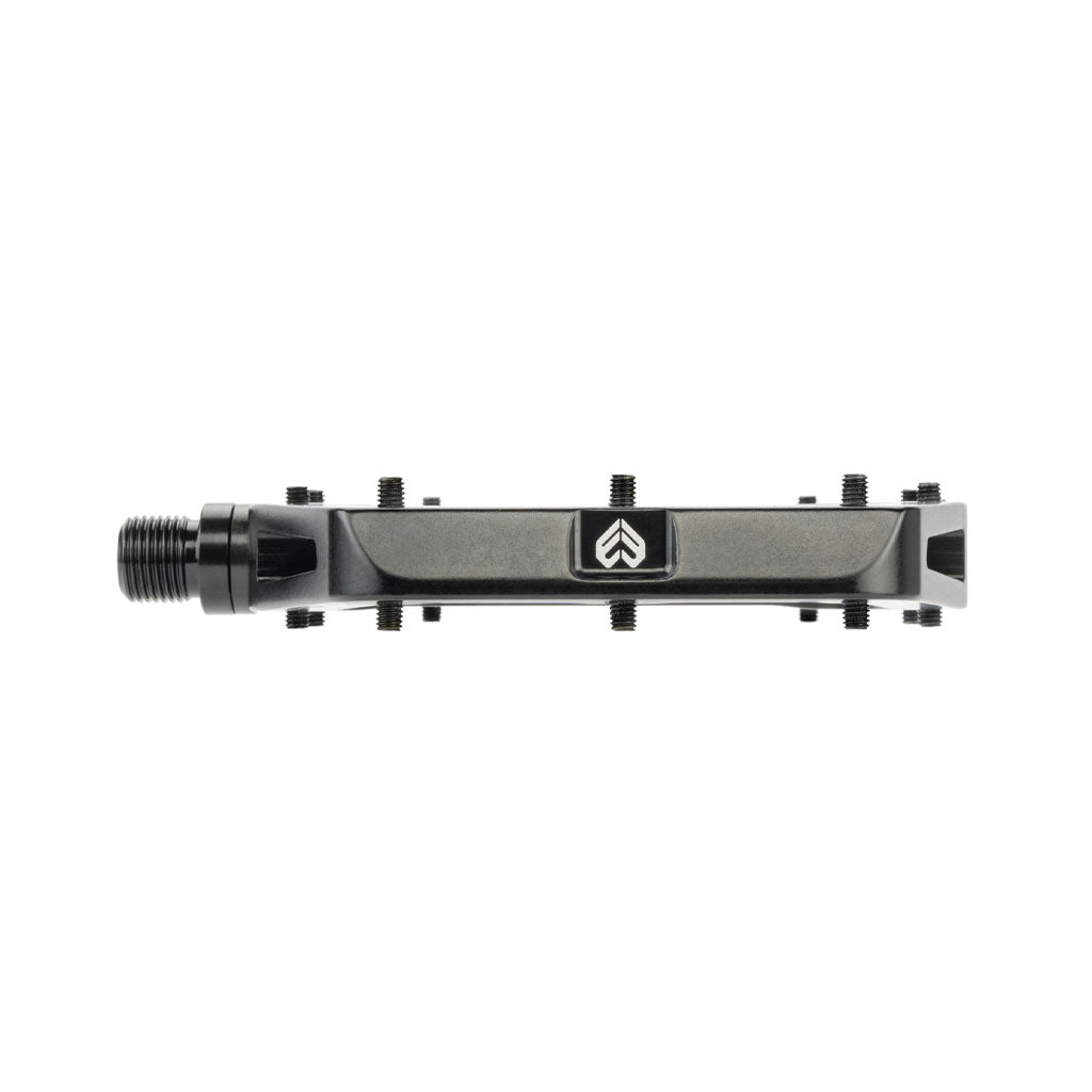 Description: The Eclat Surge XL Pedal features a single bicycle pedal with a black metal body, an oversize platform area, and a dual bearing/bushing spindle system. Multiple small bolts adorn its top surface for enhanced grip.