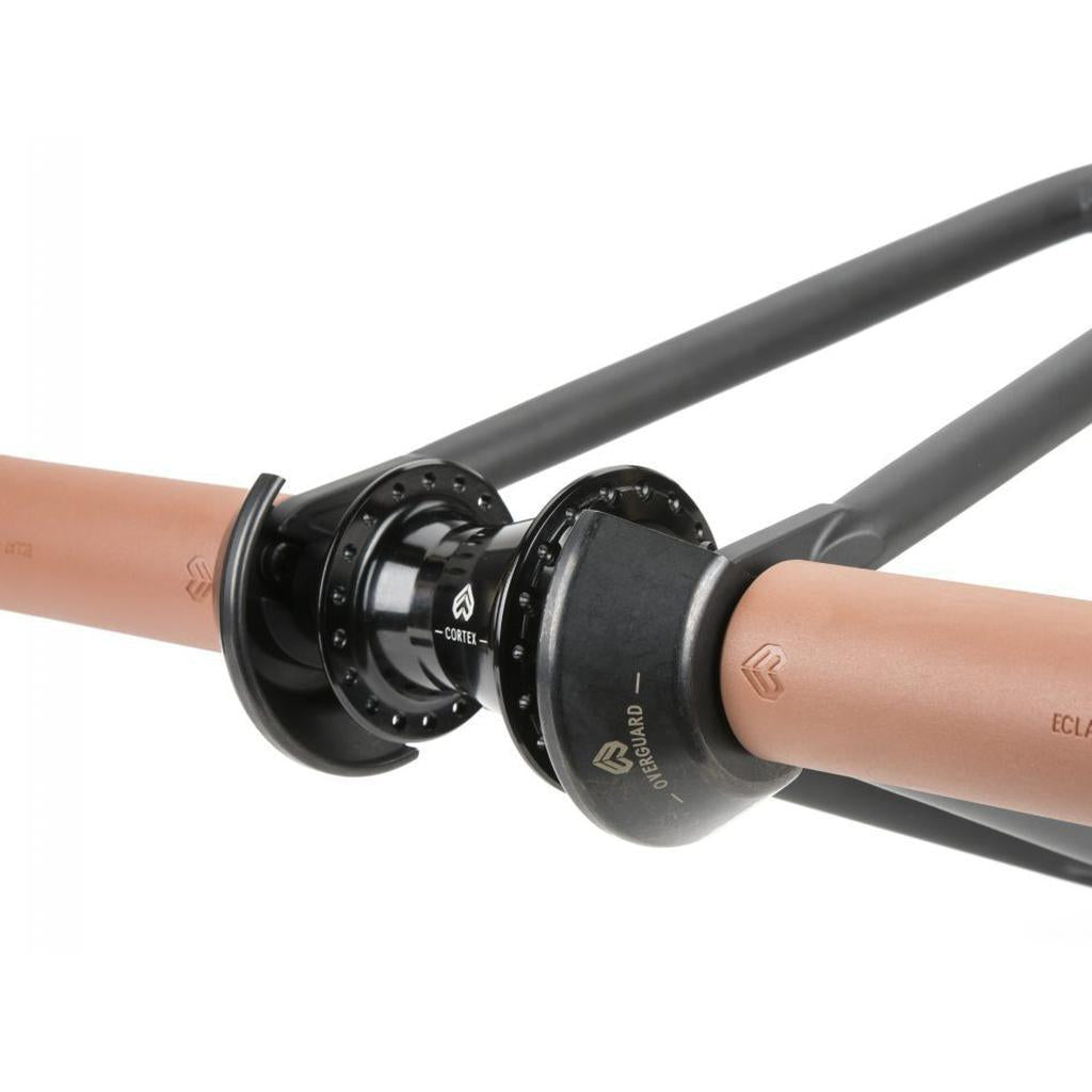 Close-up of a bicycle wheel axle with black and copper-colored components, featuring branded hubs and spokes, complemented by an Eclat Overguard Steel Universal 14mm Hub Guard for added protection.