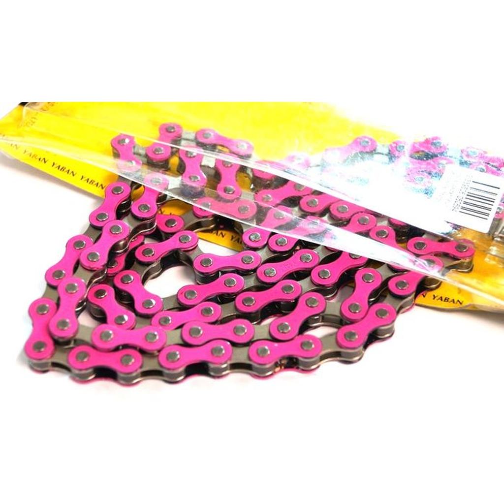 A close-up of the YBN S-410 Full Link Chain in pink and black, partially removed from yellow packaging with a barcode—a vibrant chain ideal for single speed bikes.
