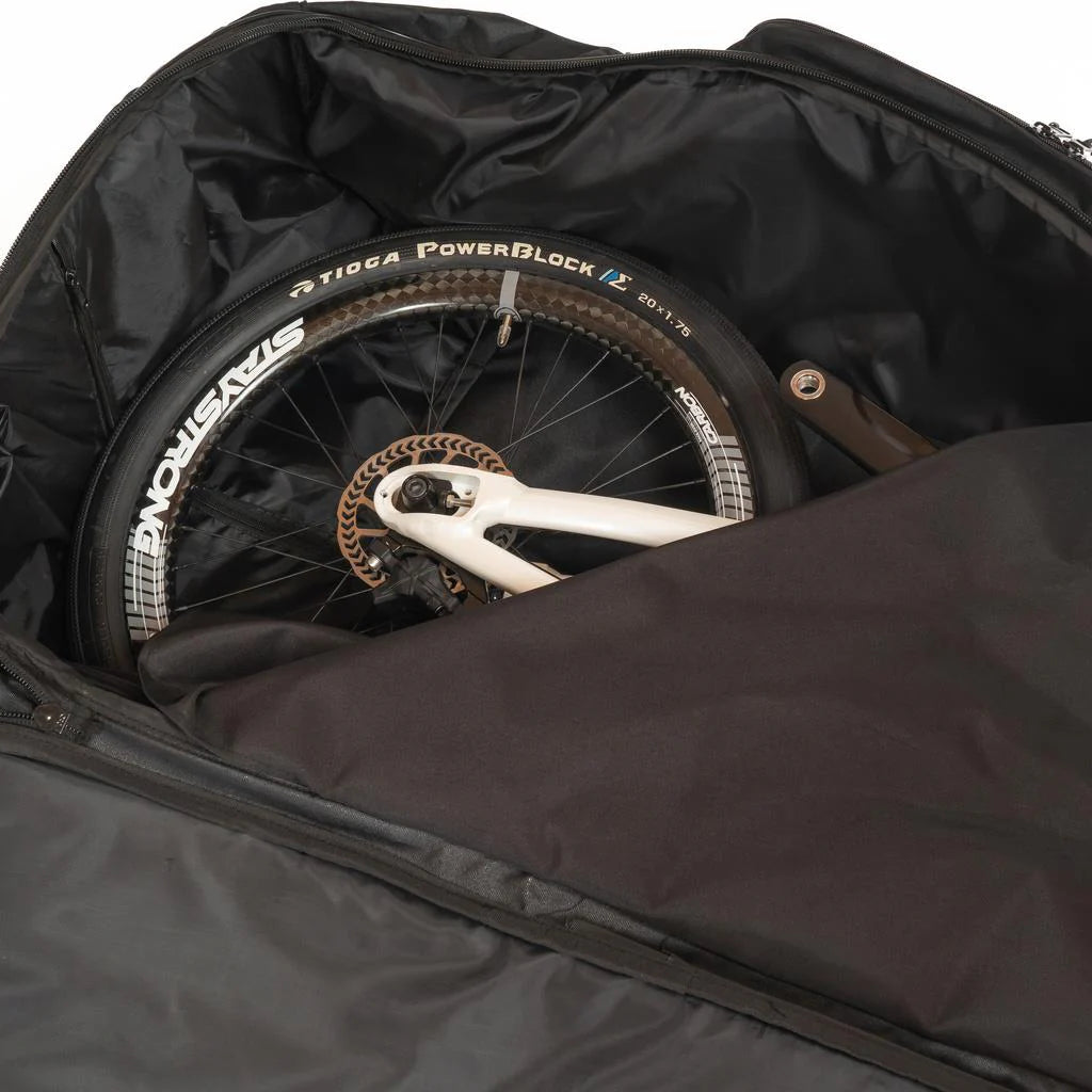 A partially disassembled bicycle is securely packed inside a Stay Strong Bike Carry Bag V2, perfect for transporting your race gear with ease.