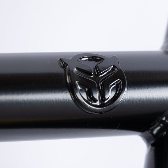 Close-up of Federal V2 4pc Drop Bars, made from 4130 CrMo with a matte black finish, featuring an embossed circular logo with abstract geometric shapes.