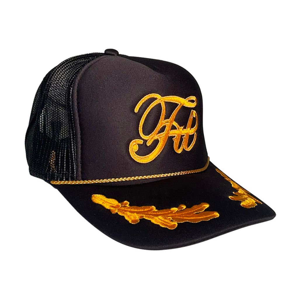 Fit Bike Co High Crowns Captains Trucker Hat with elaborate embroidery, featuring cursive initials on the front and decorative elements on the brim.