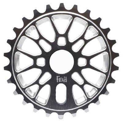 A close-up of the Fiend Omicron V2 Sprocket, a metallic BMX sprocket with 25 teeth and geometric cutouts, featuring the word “Fiend” engraved near the bottom center.