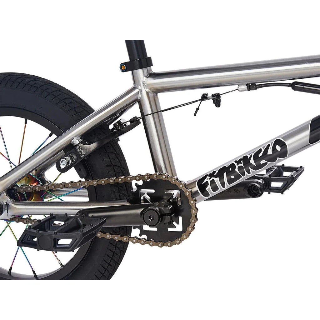 A silver bmx bike with a chain on it, featuring the Fit Misfit 14 Inch Bike (2023) / Caiden Cernius Signature.