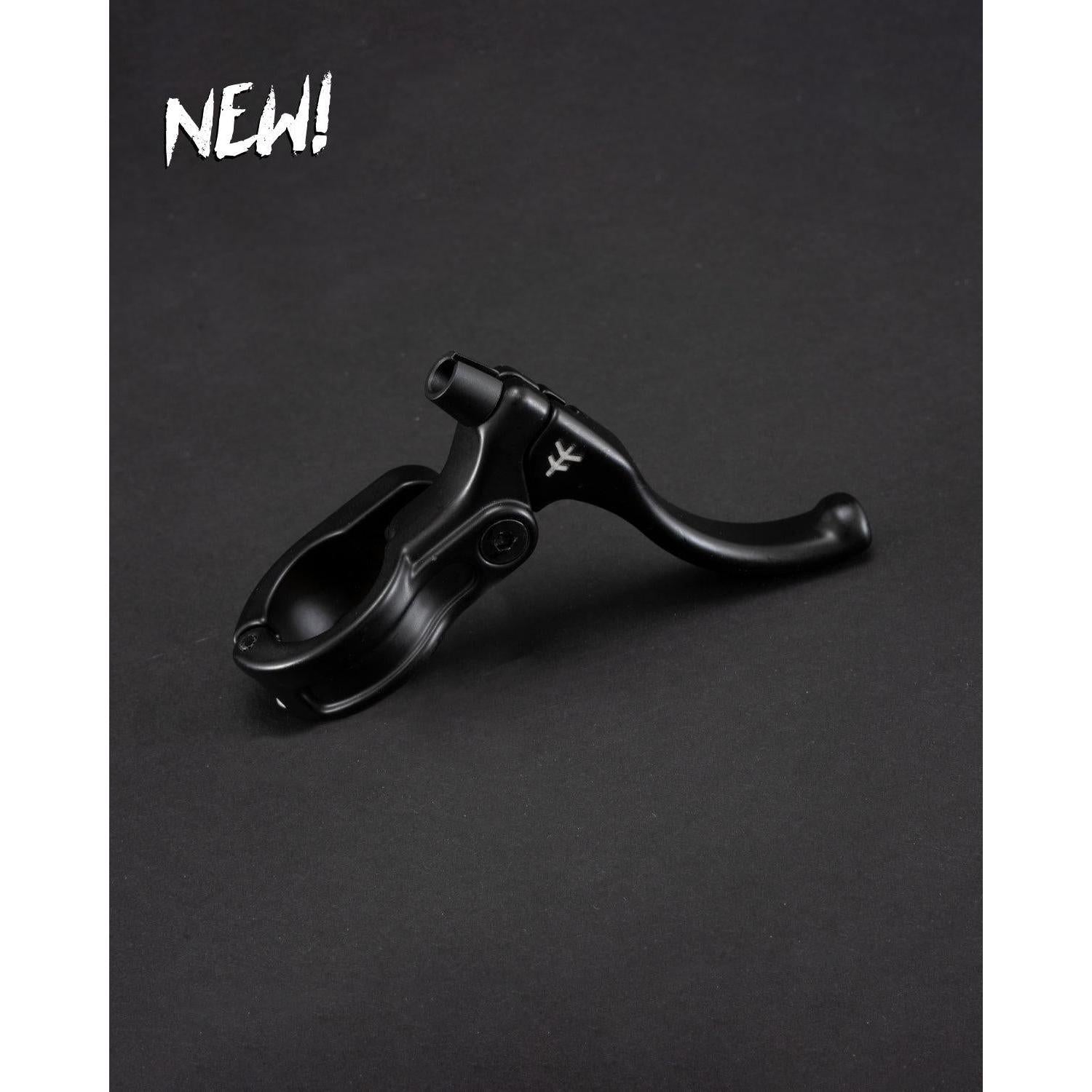 The Fly Bikes Manual Lever Mini, in black, is showcased on a dark backdrop with CNC brass bushings for precision braking. "NEW!" lights up the top left corner, highlighting this state-of-the-art addition to the collection.