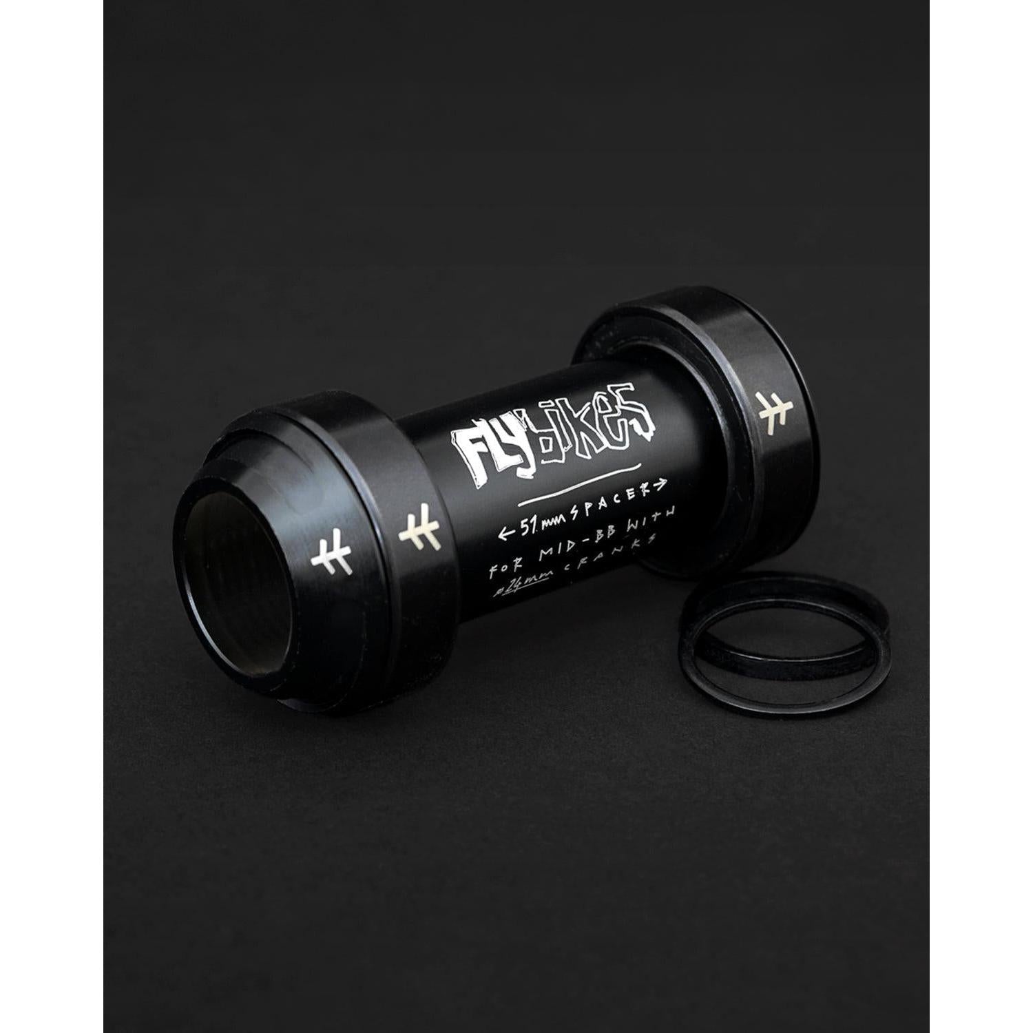 The Fly Bikes Rotar BB features CNC machined aluminum with white text and symbols on a dark surface, elegantly complemented by two neatly placed O-rings.