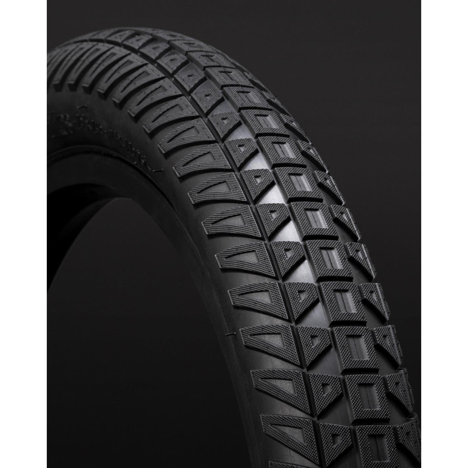 Close-up of a black Fly Bikes Ruben Tyre Ligera (Foldable) with distinct tread pattern and Kevlar folding construction against a dark background.