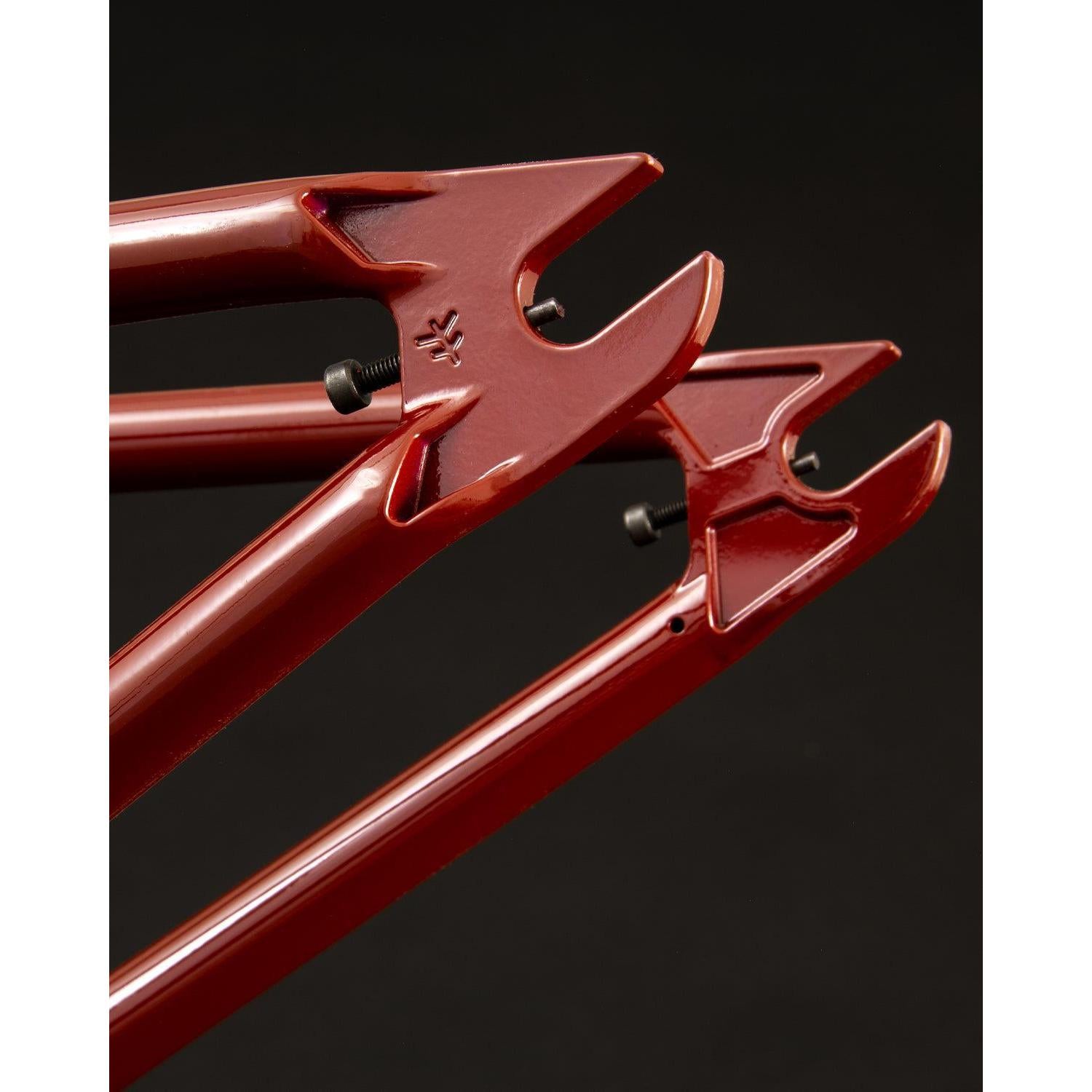 Close-up of a Fly Bikes Sierra Frame dropout on a black background, highlighting the 4130 CrMo steel rear fork ends with bolt holes.