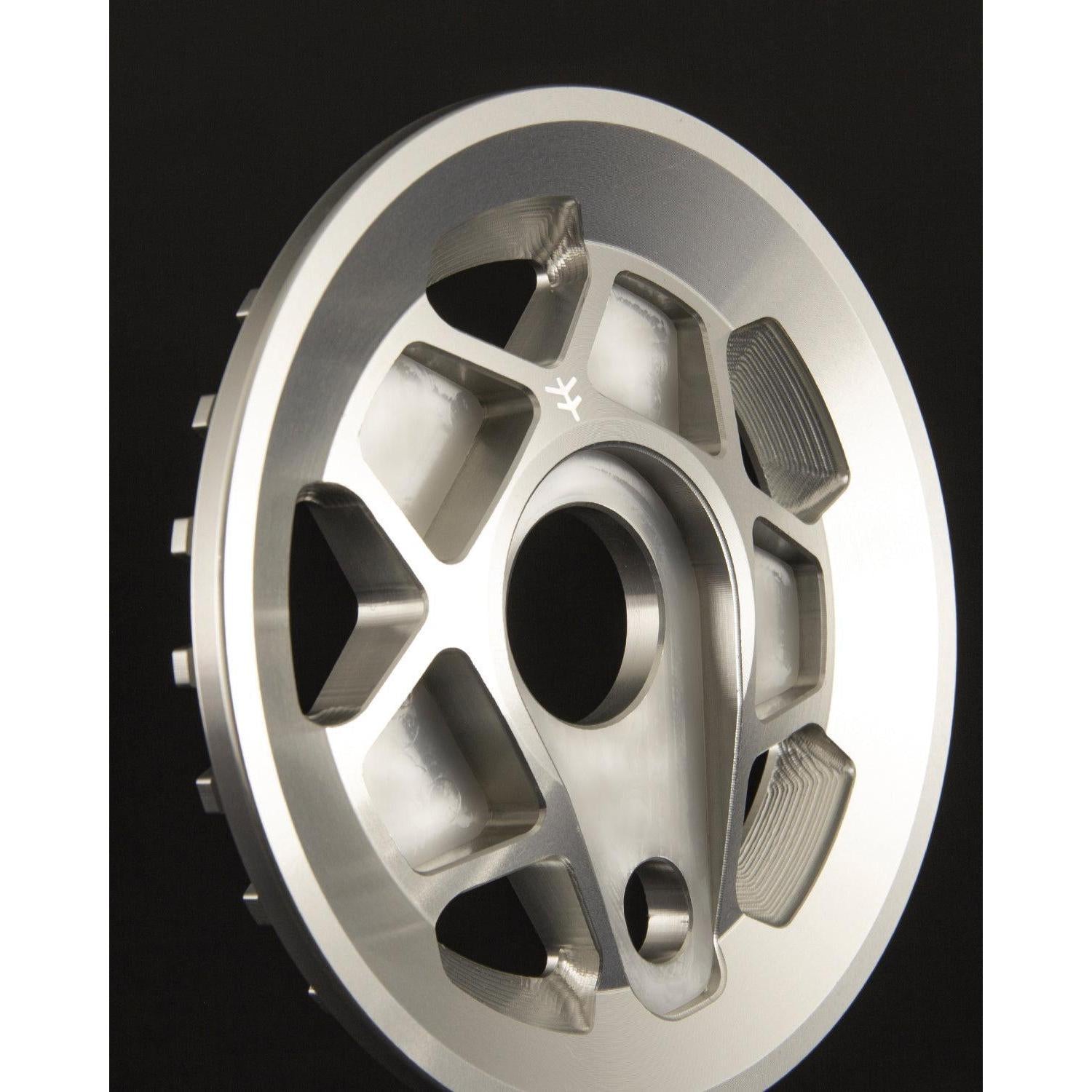 Close-up of a CNC machined Fly Bikes Tractor Guard Sprocket, made from 6061 Aluminum, showcasing multiple holes and a central opening, set against a dark background.