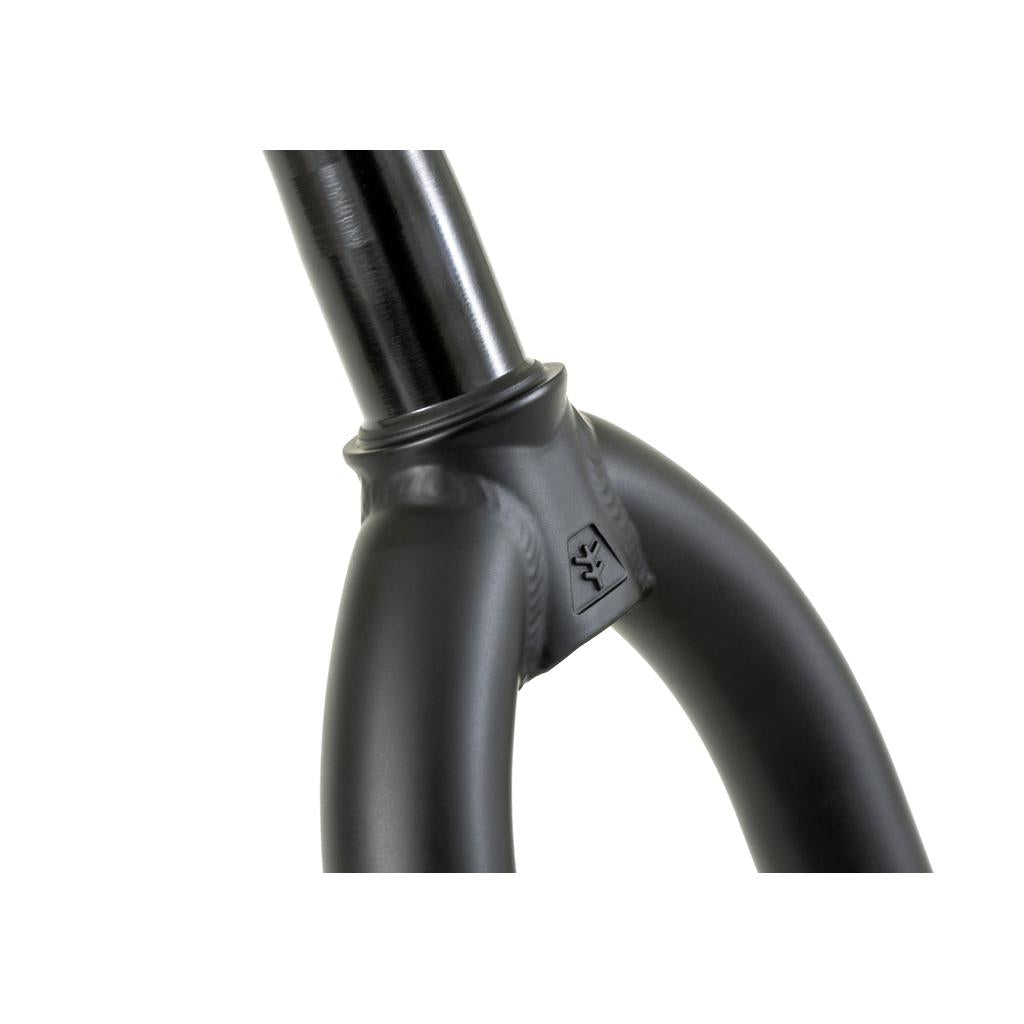 A close-up of Fly Bikes Volcano Forks shows a black BMX steer-tube with a ridged crown junction, excellent tire clearance, and a small engraved logo on the side.
