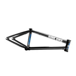 The Kink Williams (Nathan Williams Signature) Frame in matte black with white and blue lettering is showcased on a concrete surface with a dark backdrop.