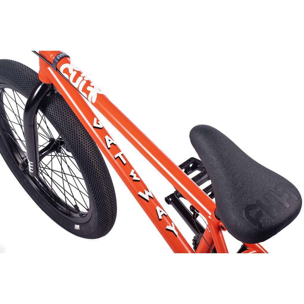 Close-up of an orange Cult Gateway 20 Inch Bike with "GATEWAY" on the frame, a black textured seat, and a rear wheel fitted with a thick tread tire.