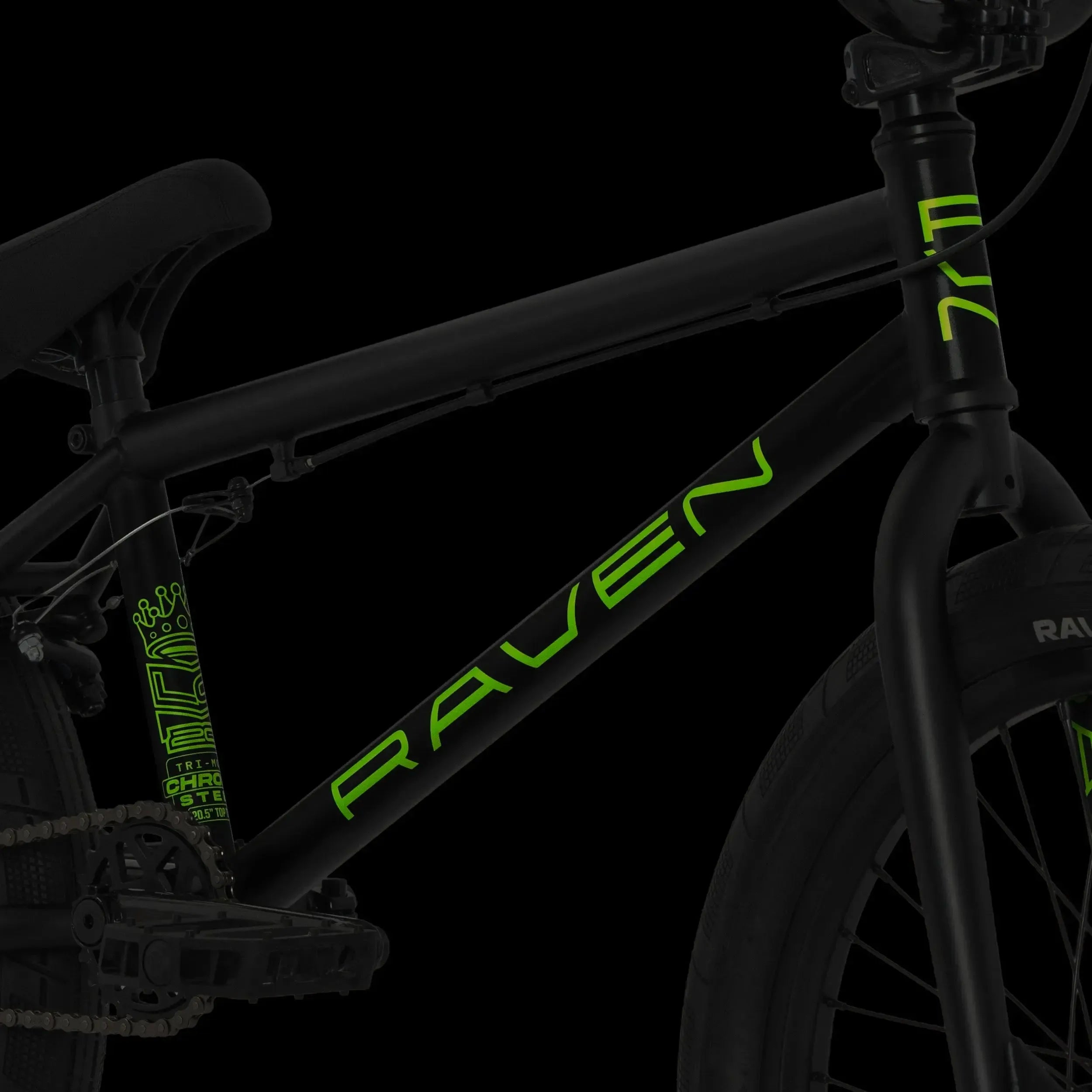 Close-up of the Raven LC 20 Inch Bike, featuring a black frame with "RAVEN" in green lettering. Visible pedal, seat, and front fork stand out against a black background, while the chromoly frame showcases durability and performance.