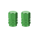 A pair of Hexagon Valve Caps in vibrant green metal is displayed on a pristine white background, perfect for adding a pop of color to any ride.