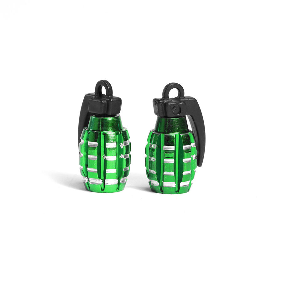 A pair of small, green, grenade-shaped Grenade Valve Caps with black tops are displayed upright on a white background.