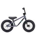 The Kink Coast 12 Inch Balance Bike (2026) features a sleek dark metallic frame and sturdy black wheels, set against a clean white background. It's the perfect introduction to biking for budding BMX enthusiasts.