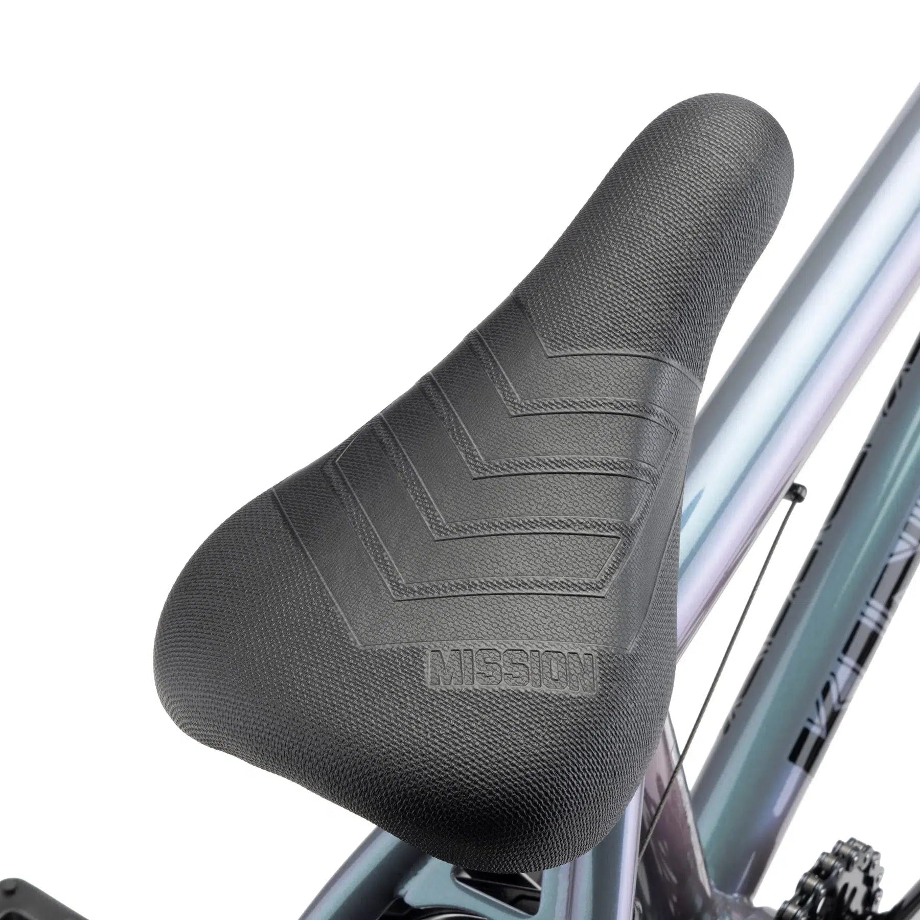 Detailed view of a black bicycle seat embossed with "MISSION," fixed to the frame of a silver and purple gradient Kink Kicker 18 Inch Bike, ideal for younger riders looking for excellent ride quality.