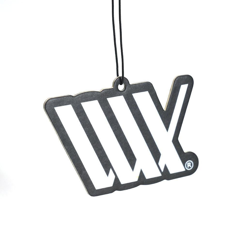 The LUXBMX Air Freshener - Josh Dove hangs by a black string against a white background, displaying WLX in white letters and infusing any space with a refreshing black forest scent.
