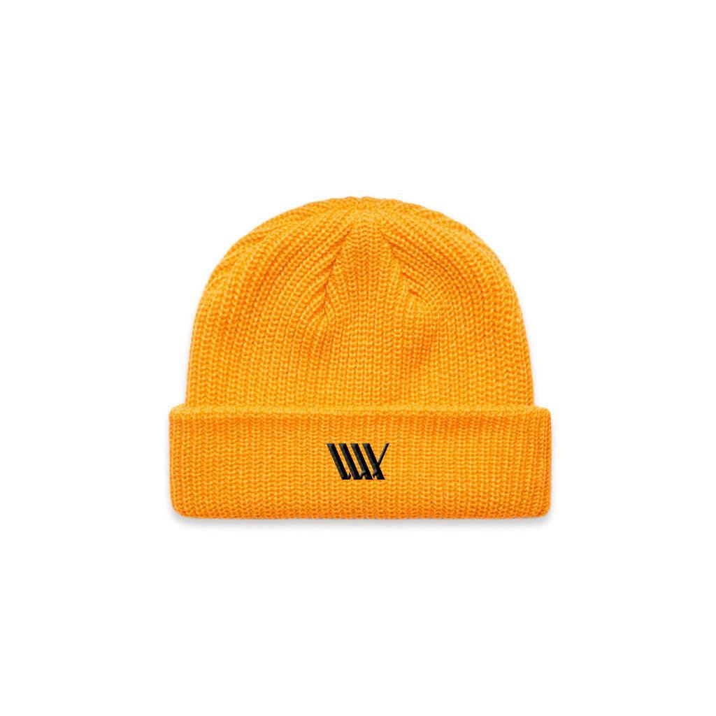 The LUXBMX Flag Beanie - Yellow is crafted from mid-weight acrylic, features a folded brim, and displays a small black geometric logo on the front.