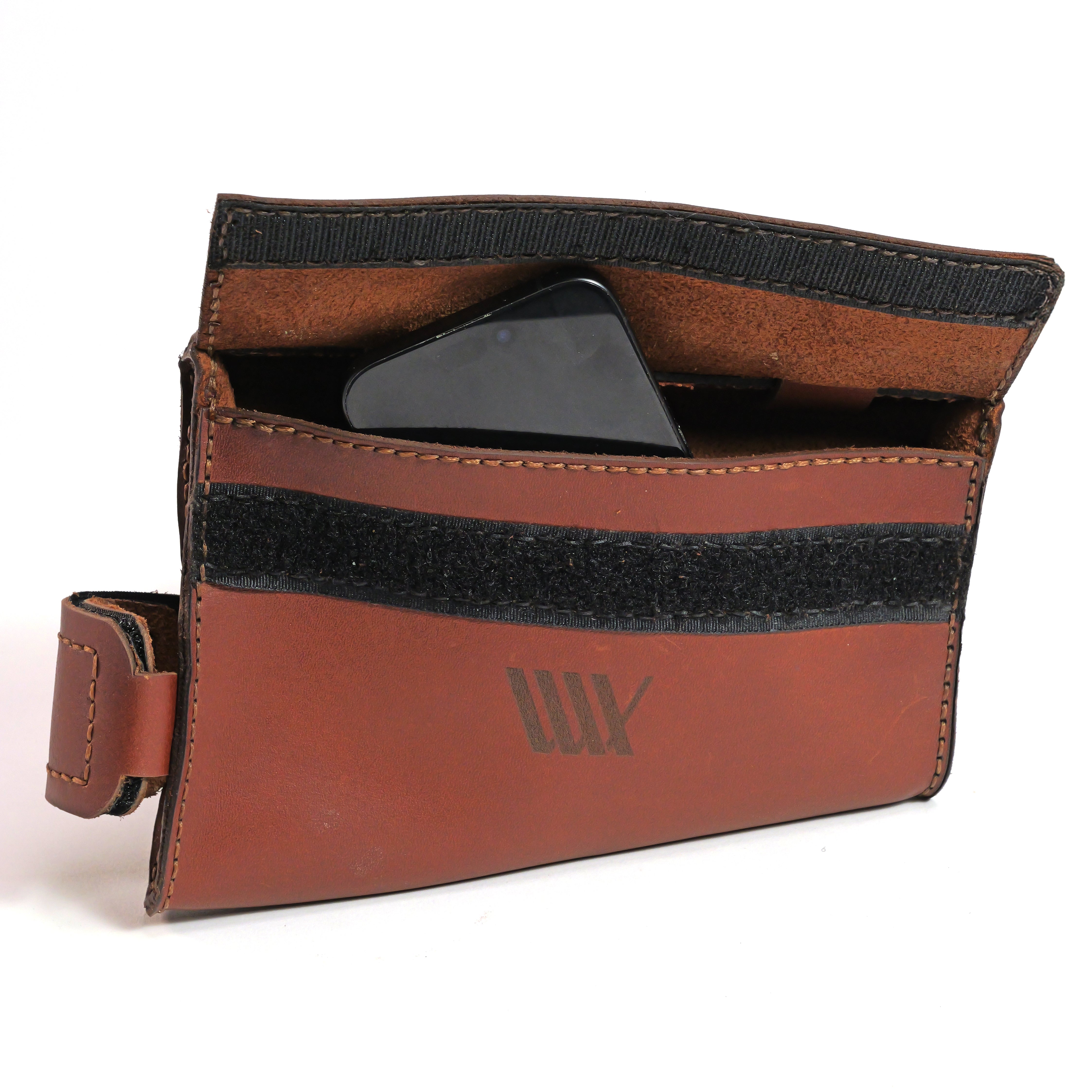 The LUXBMX Leather Frame Bag, handmade in Queensland from brown full-grain leather with a velcro closure, is shown partially open to reveal a black smartphone inside.