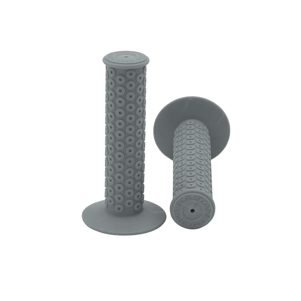 Two gray Kastan Grips feature a circular raised-bump pattern, wide flanges, and flat end caps with embossed text—ideal for a rubber RL II era-correct build.