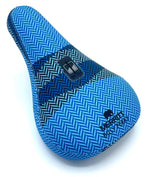 The Merritt Billy Perry Pivotal Seat features a blue chevron pattern, durable canvas cover, rectangular black mounting slot, and "MERRITT BMX PERA" branding on the front.